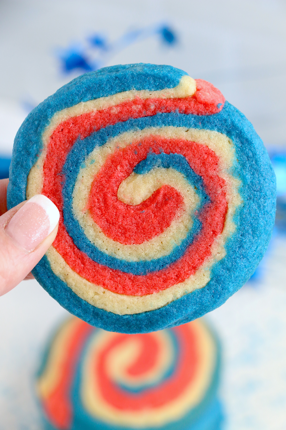 hand holding a 4th of July pinwheel cookie