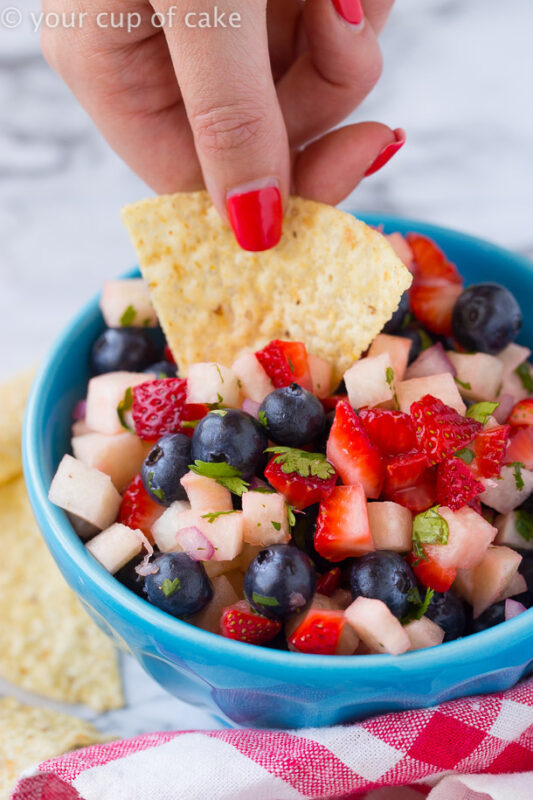 chip dipping into a 4th of July fruit salad