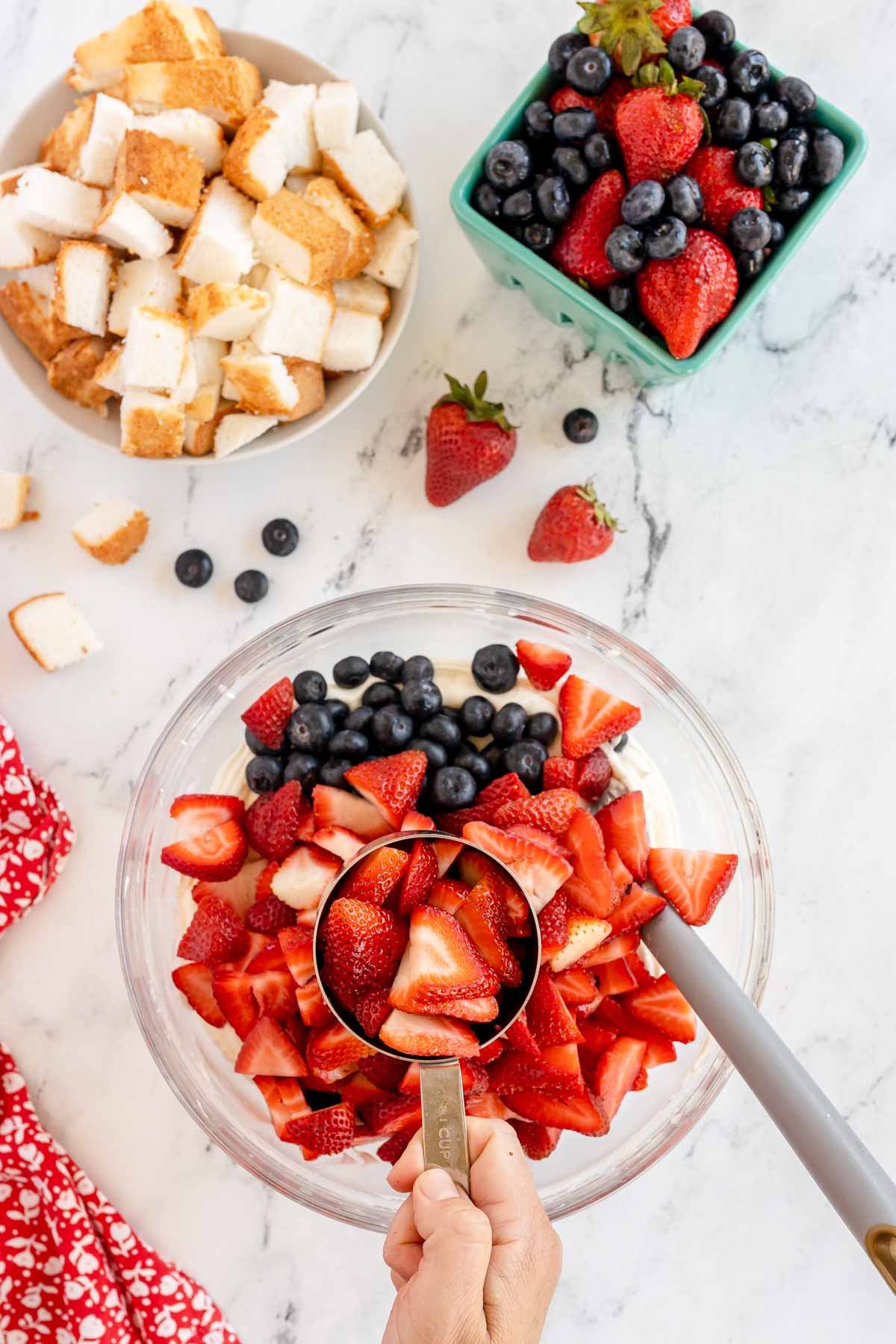 blueberries and strawberries in a bowl of cheesecake fluff