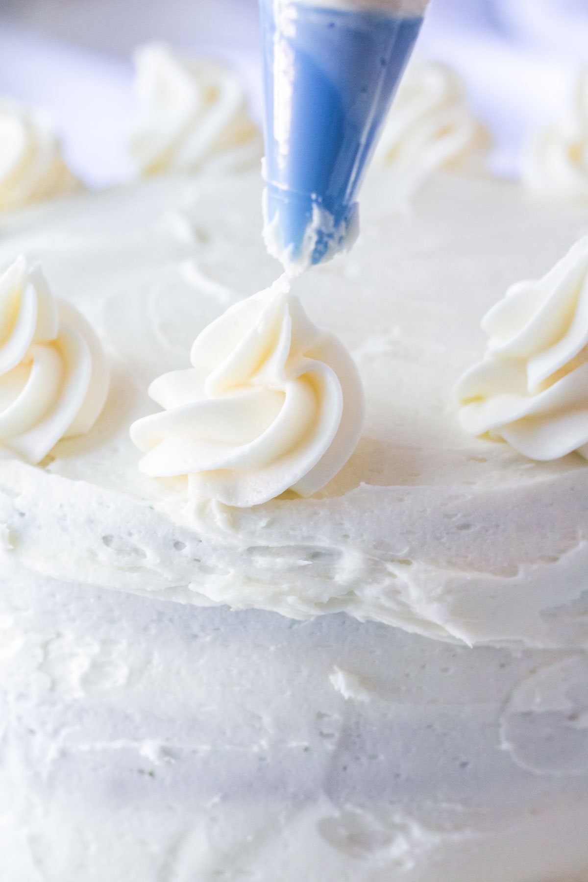 piping buttercream on top of a red white and blue cake