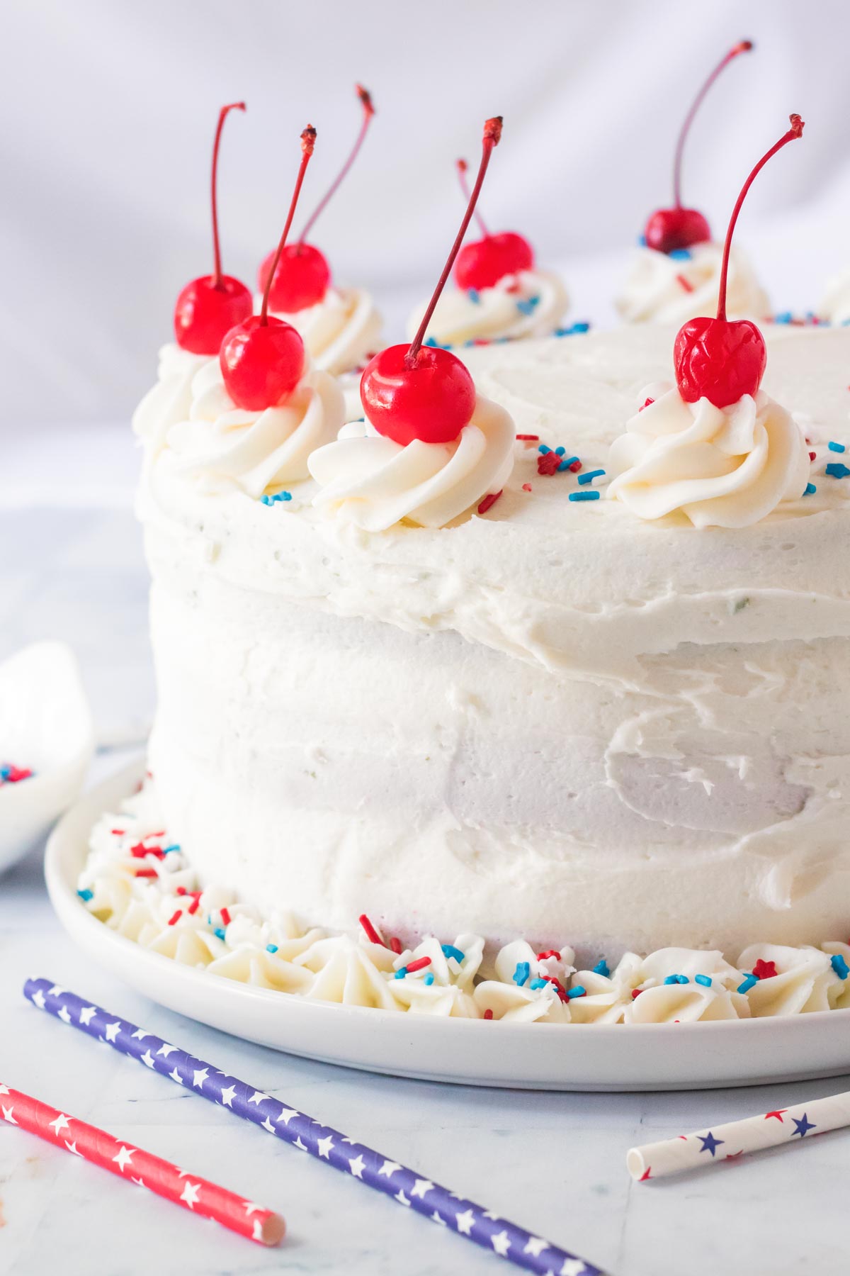 red white and blue cake topped with cherries