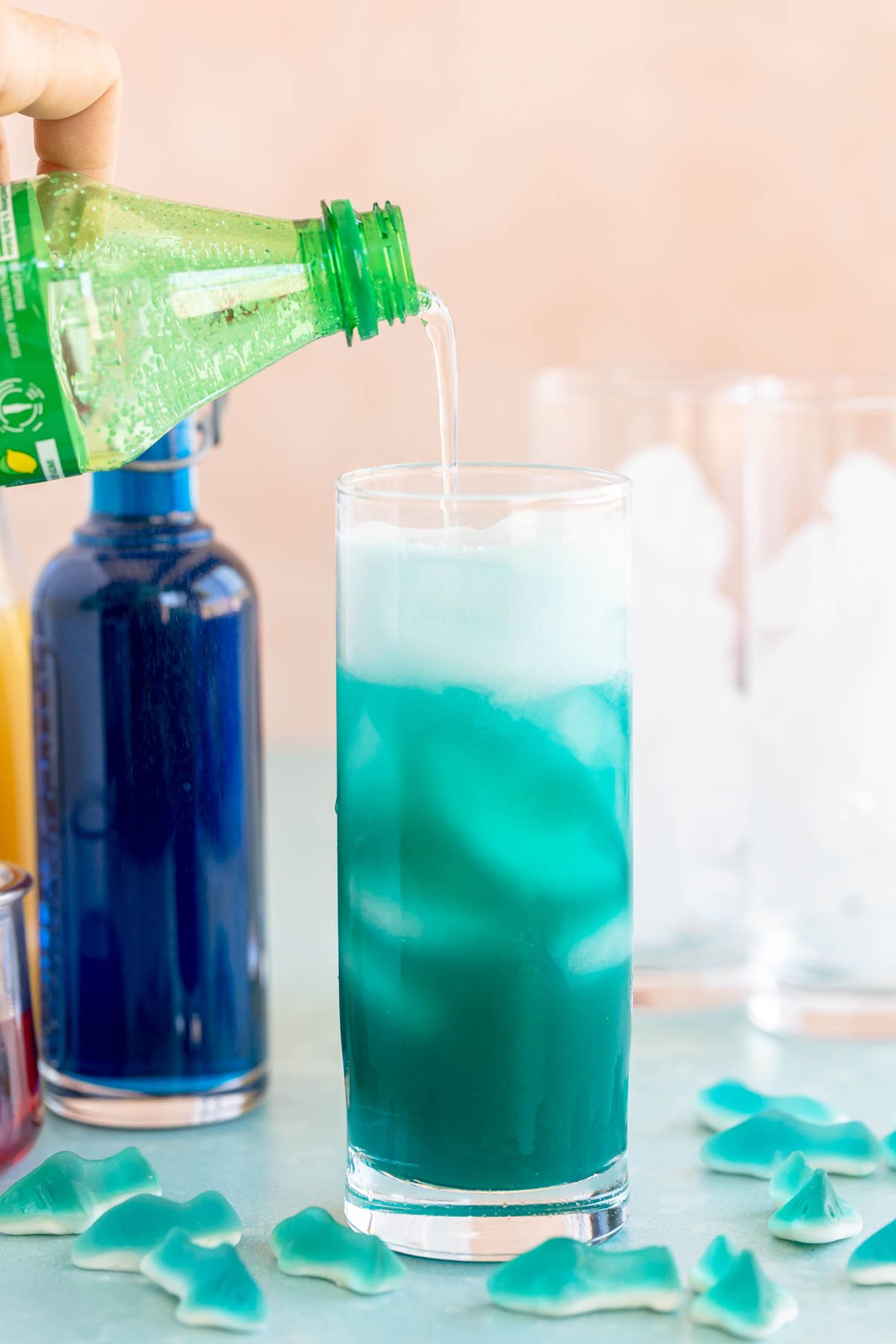 pouring Sprite into a glass of blue punch