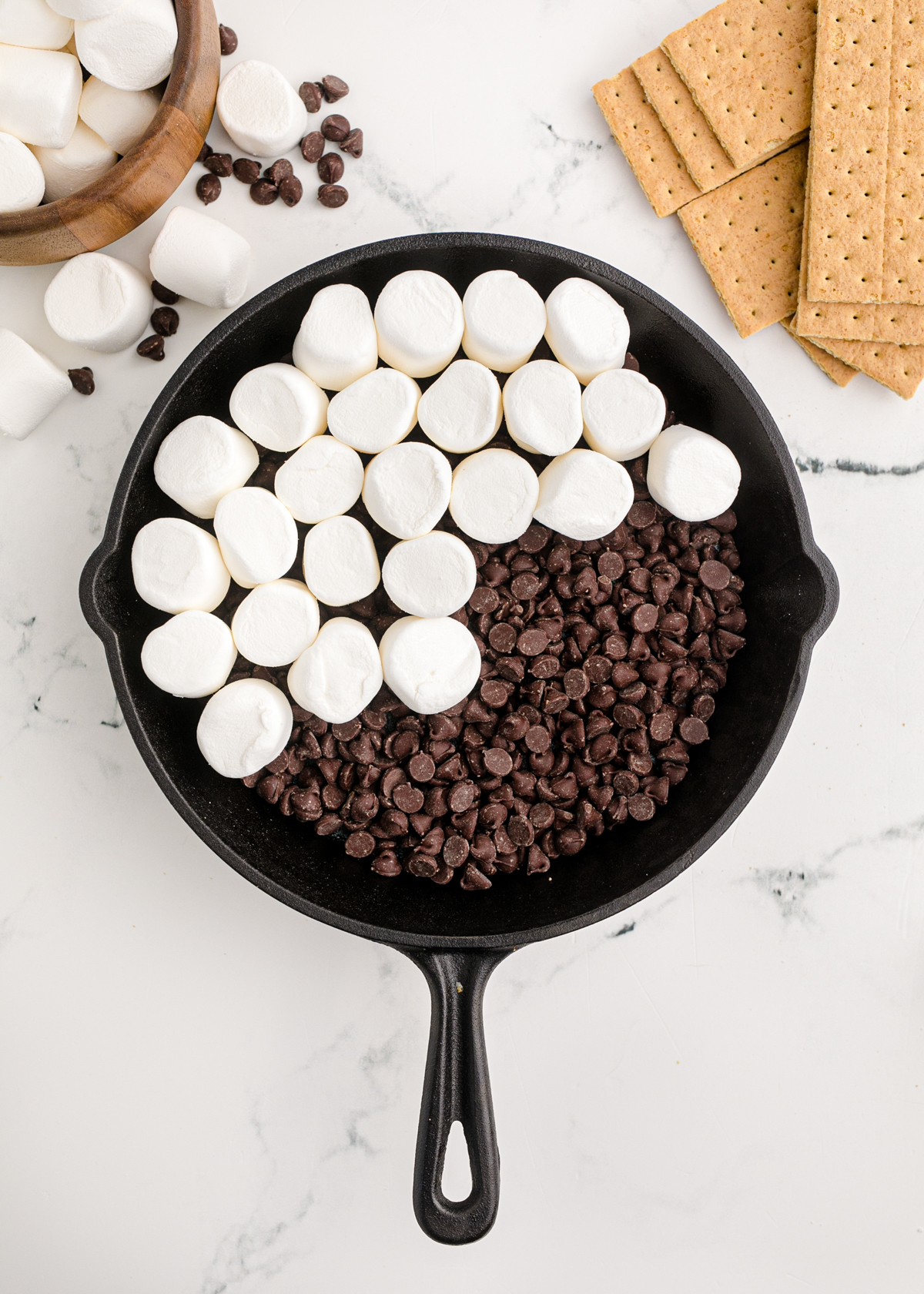 marshmallows on top of chocolate in a cast iron skillet
