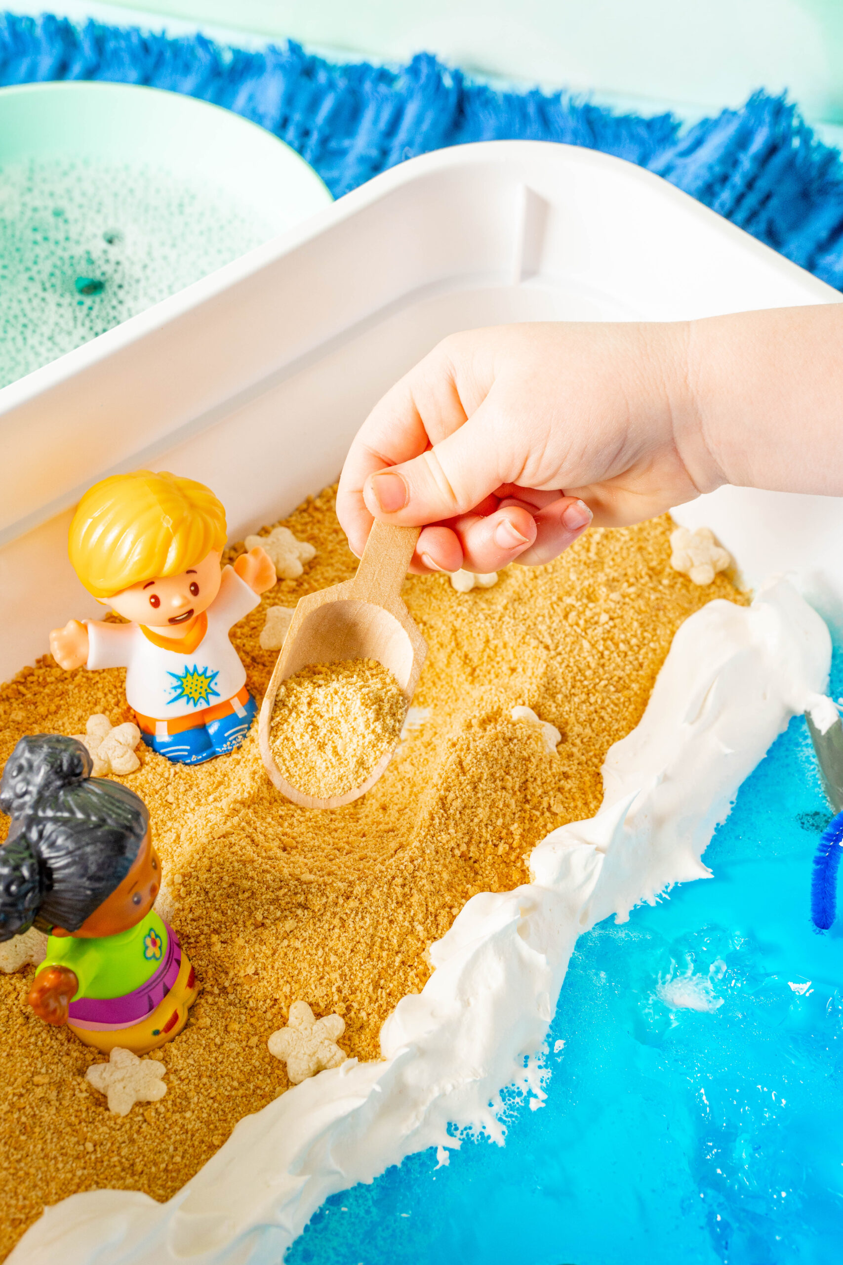 kid digging sand in an ocean sensory bin
