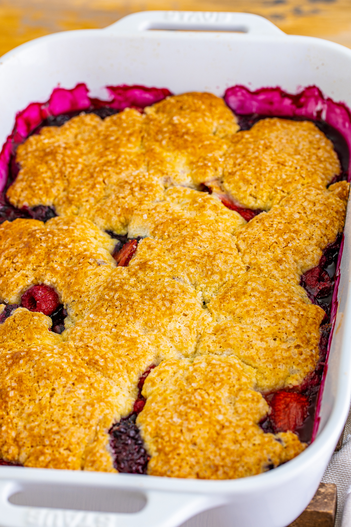 baked mixed berry cobbler in a white dish