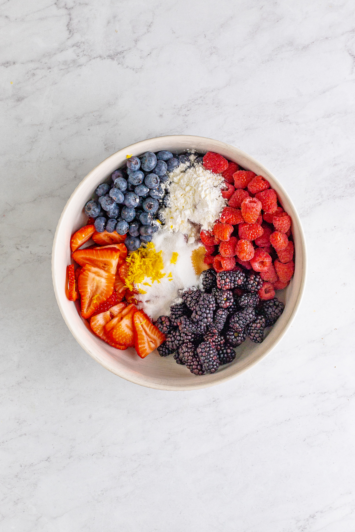 white bowl with berries and other ingredients in it
