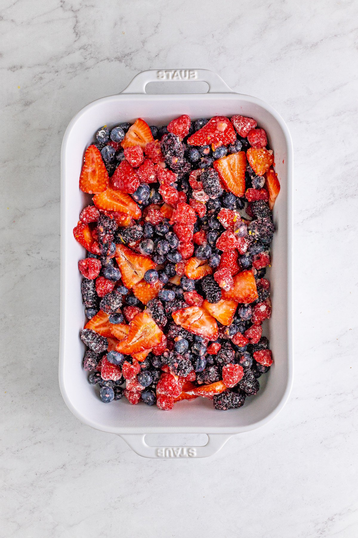 berries in a baking dish for mixed berry cobbler