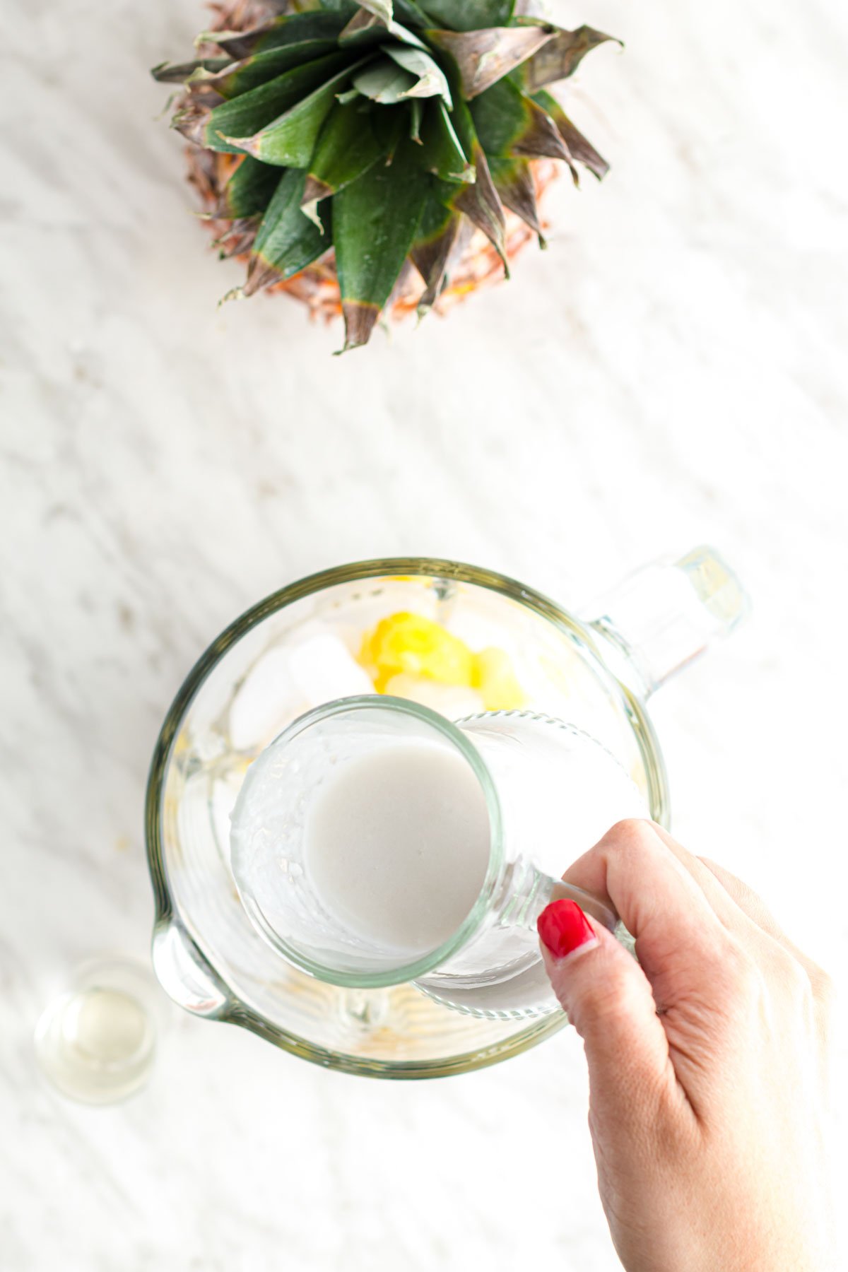 pouring coconut milk into a blender