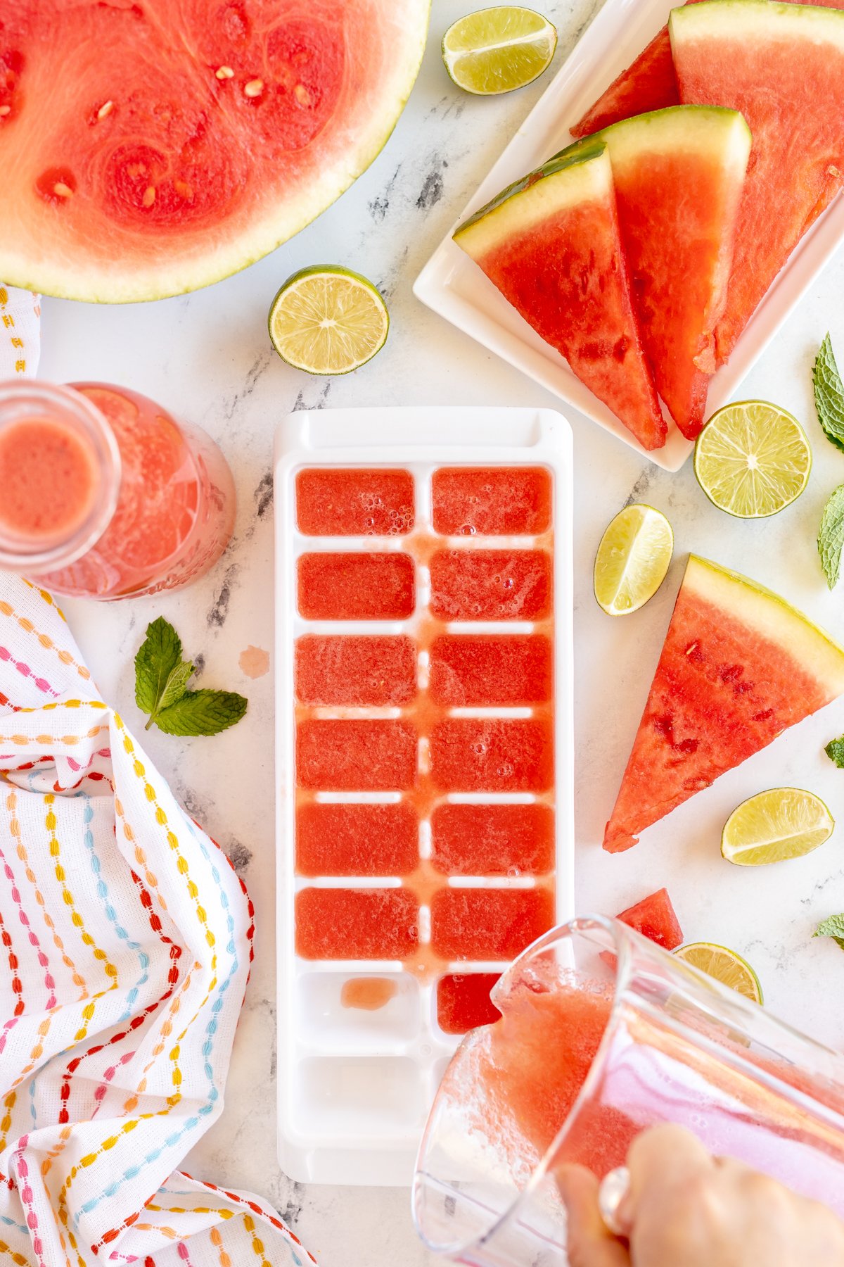 pouring watermelon juice into ice cube trays