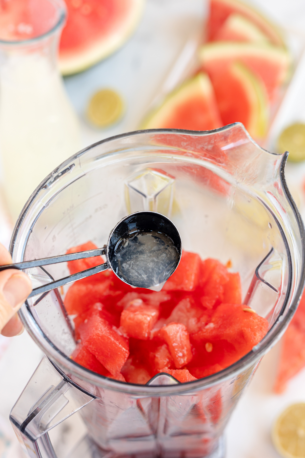 adding lemon juice and watermelon into a blender