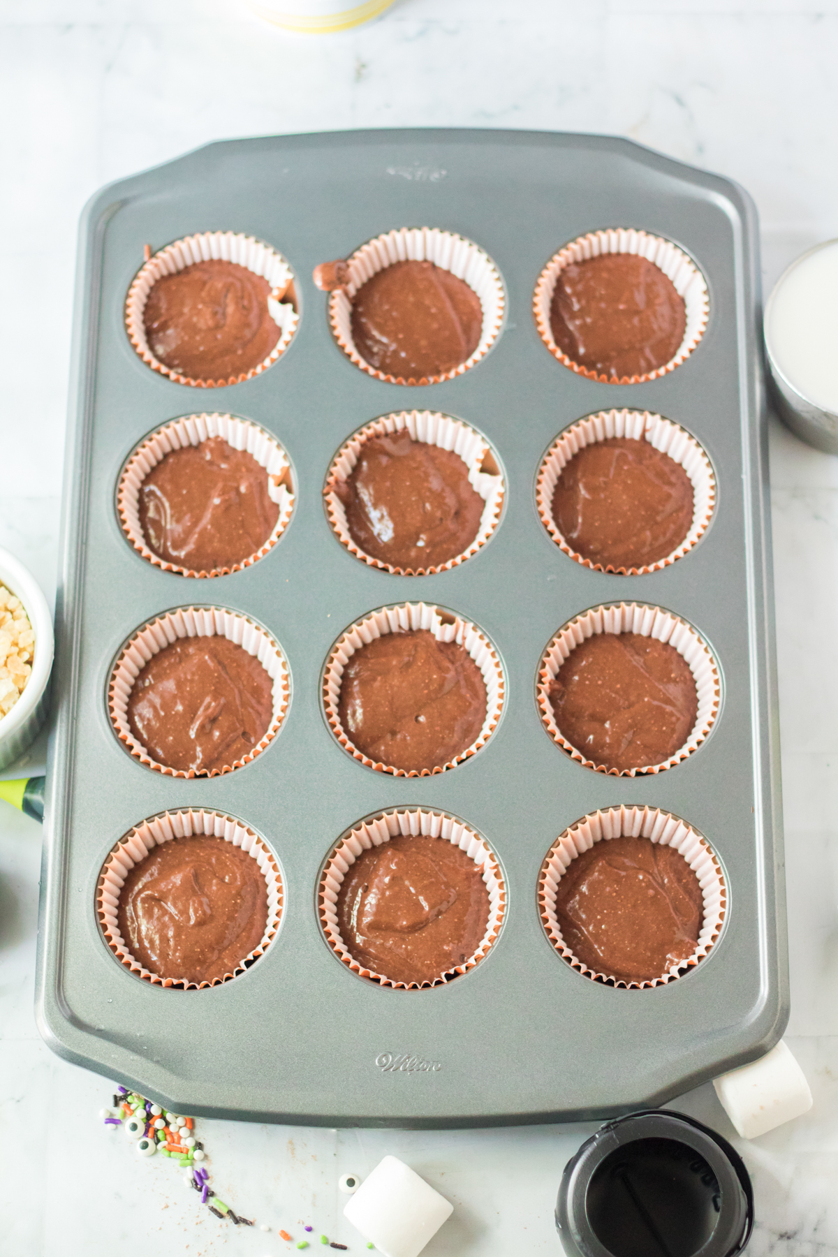 muffin tin with chocolate cupcake batter