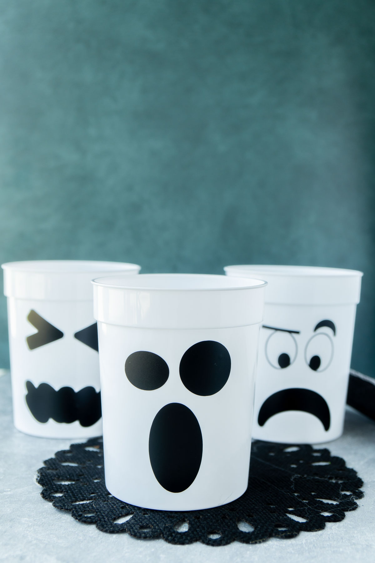 three white ghost cups with a green background