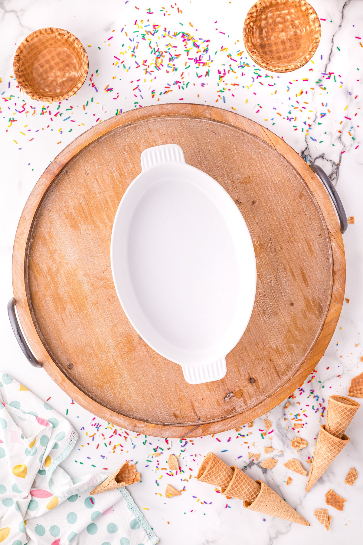 oval bowl in the center of a wood cheese board