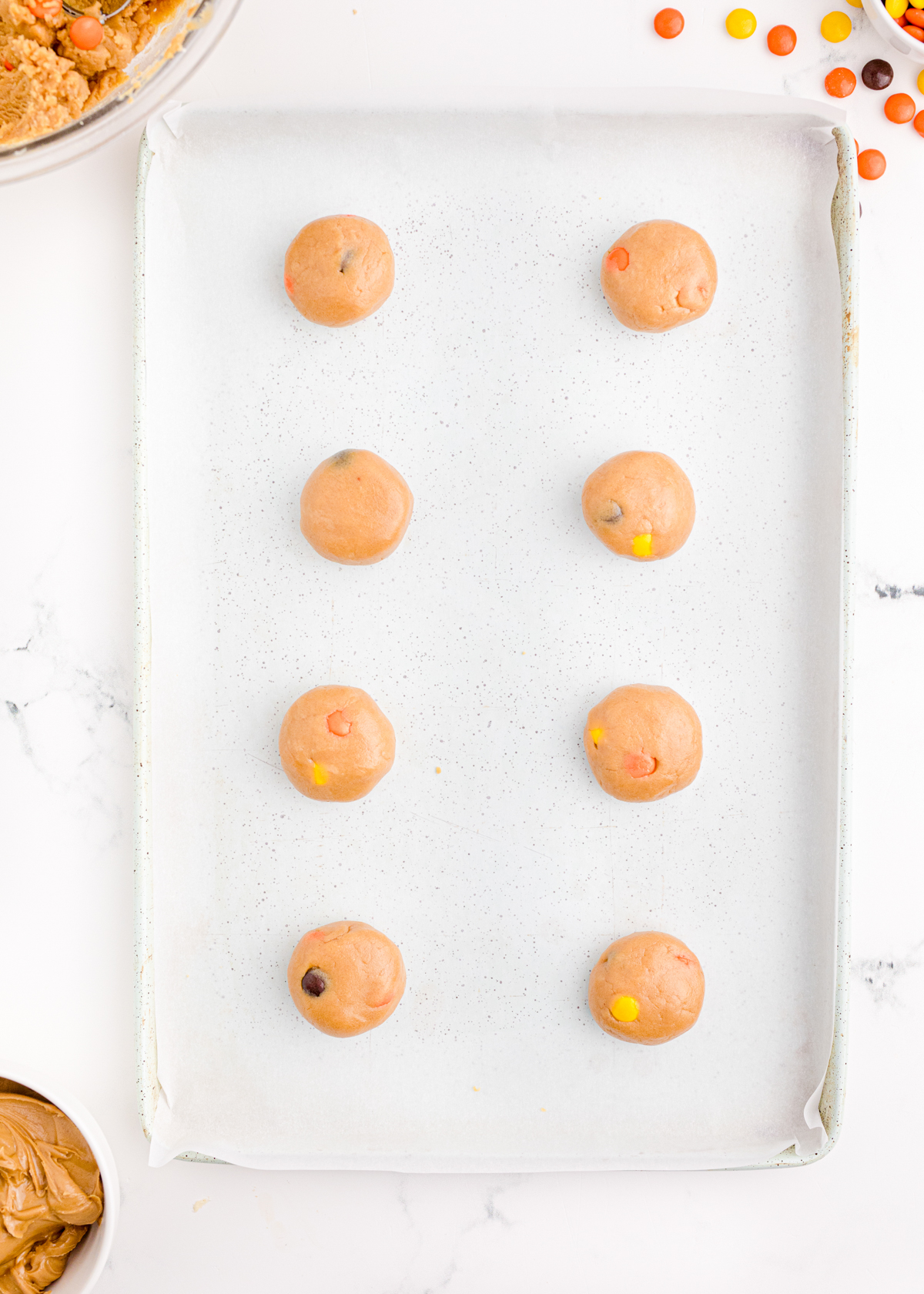 unbaked reese's pieces cookies on a baking sheet