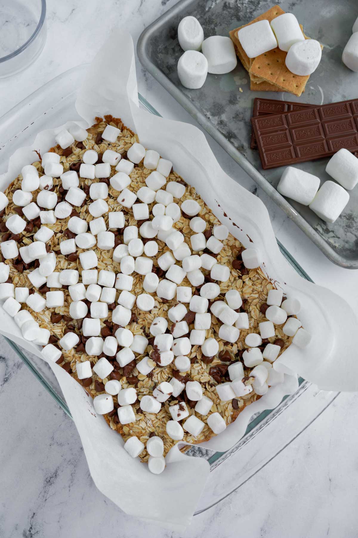 mini marshmallows on s'mores bars in a baking pan