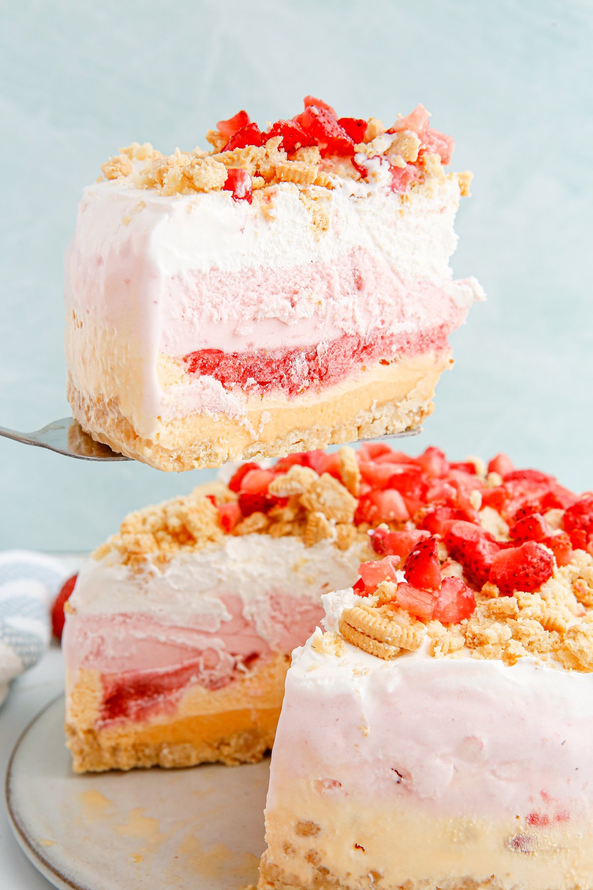 spatula removing a slice of strawberry ice cream cake