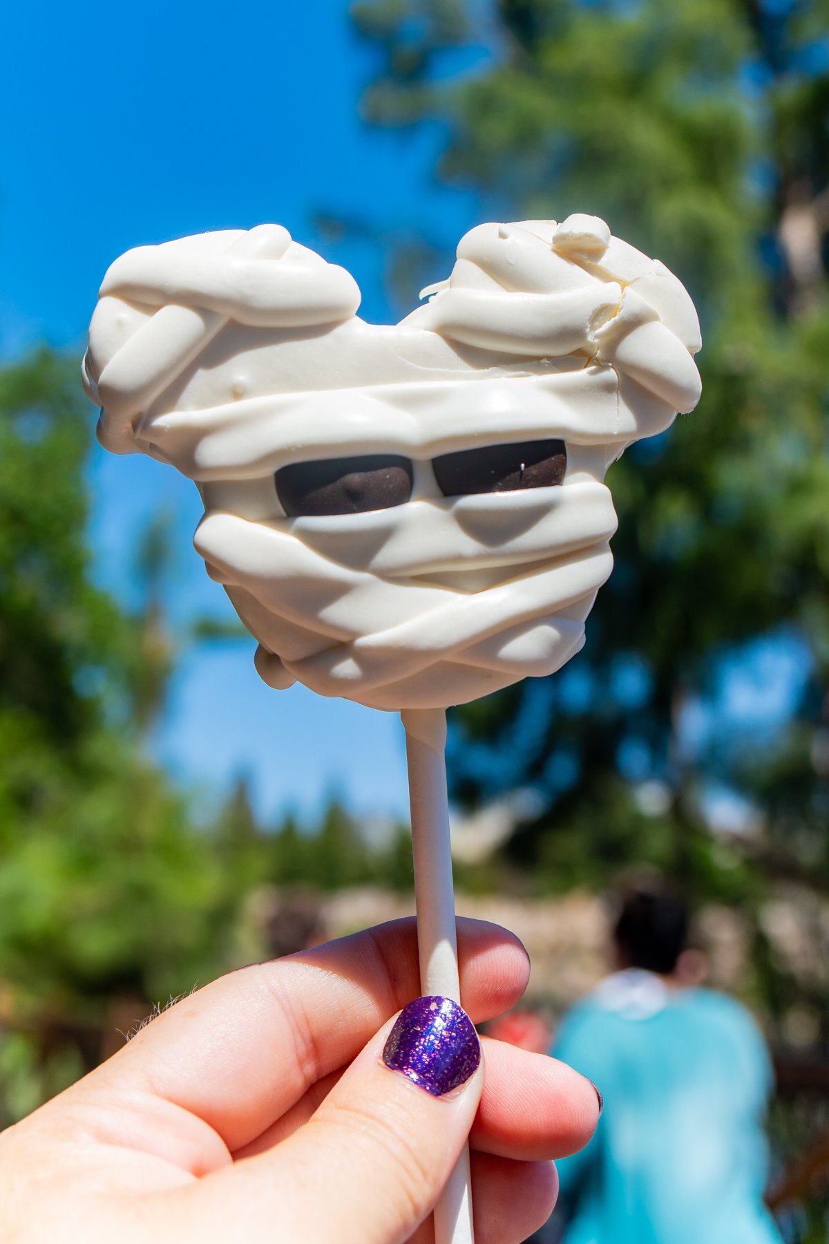 hand holding a Mickey shaped mummy marshmallow