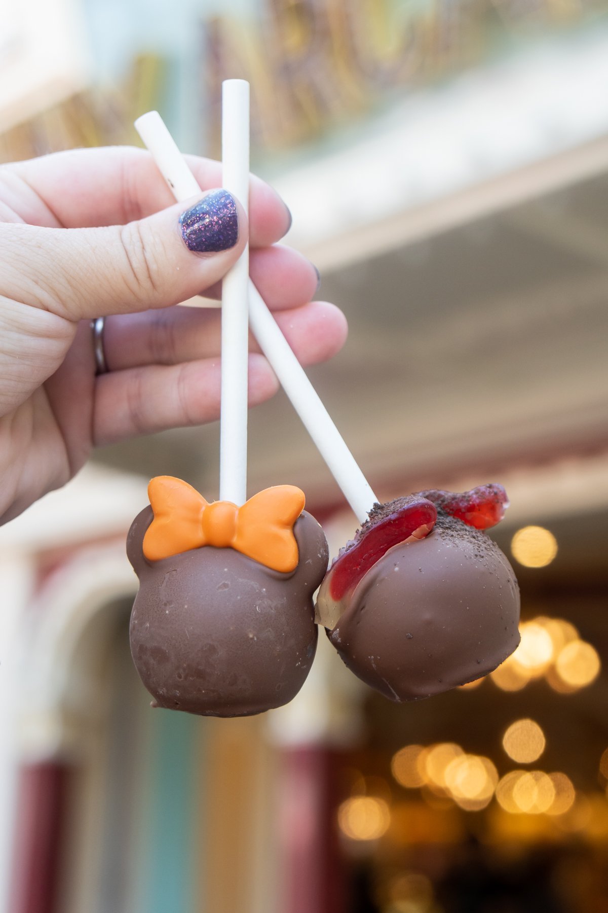 hand holding two chocolate cake pops