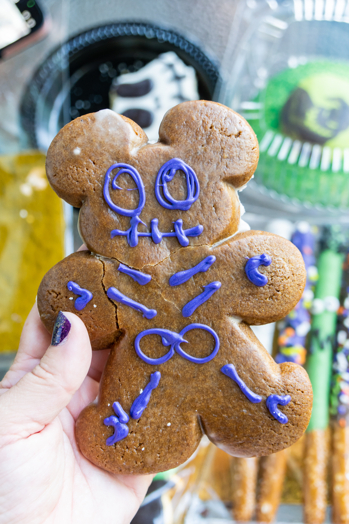 hand holding a gingerbread zombie cookie