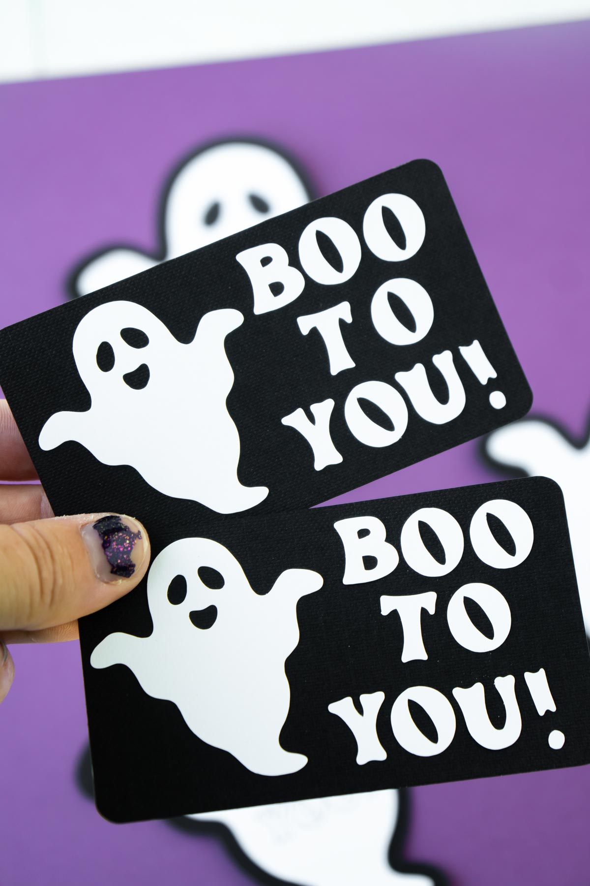 hand holding Cricut made boo to you tags
