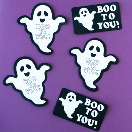 Ghost tags cut out with a Cricut on a purple background