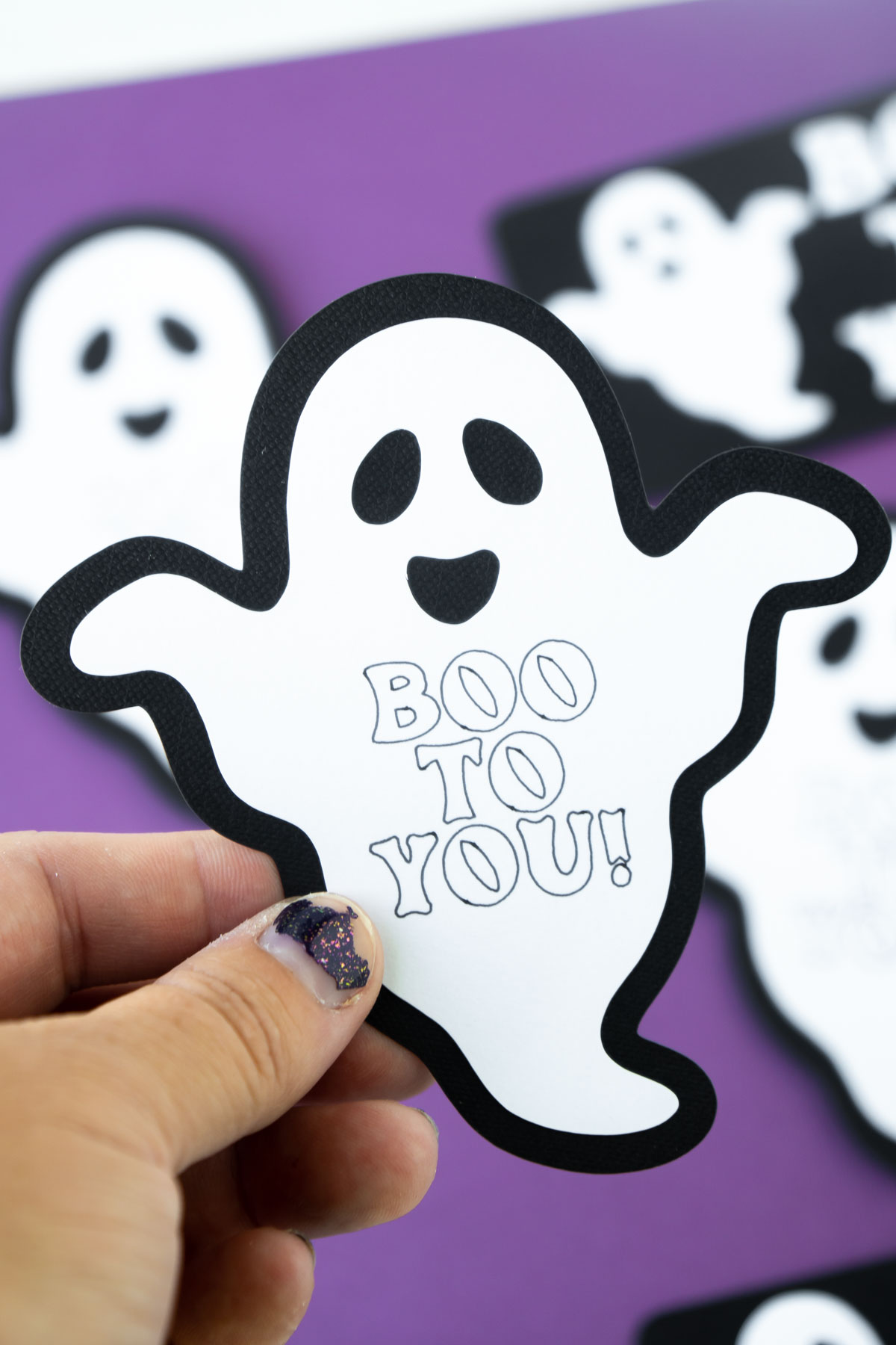hand holding a Boo to You ghost tag