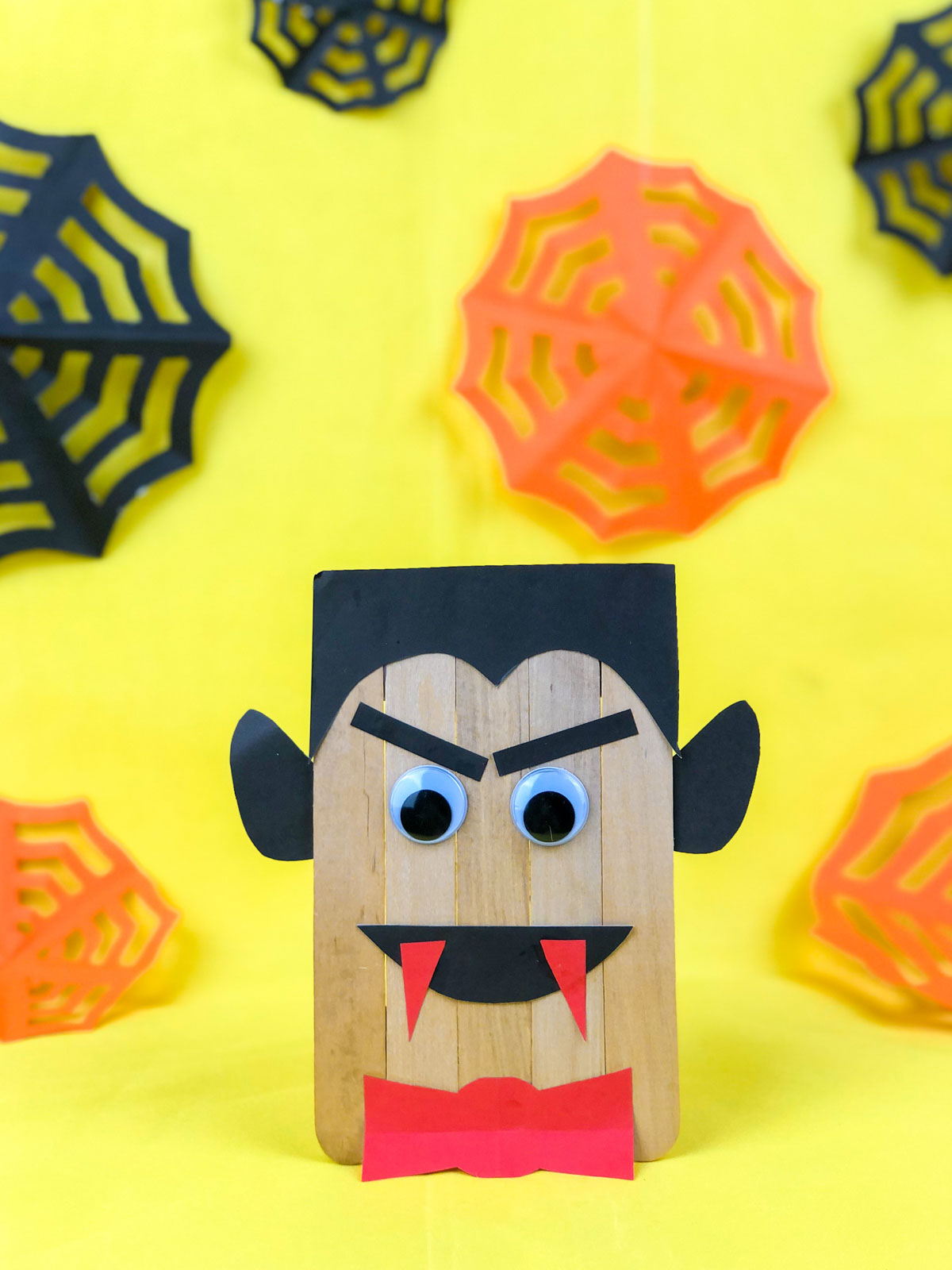 popsicle stick vampire with a yellow background