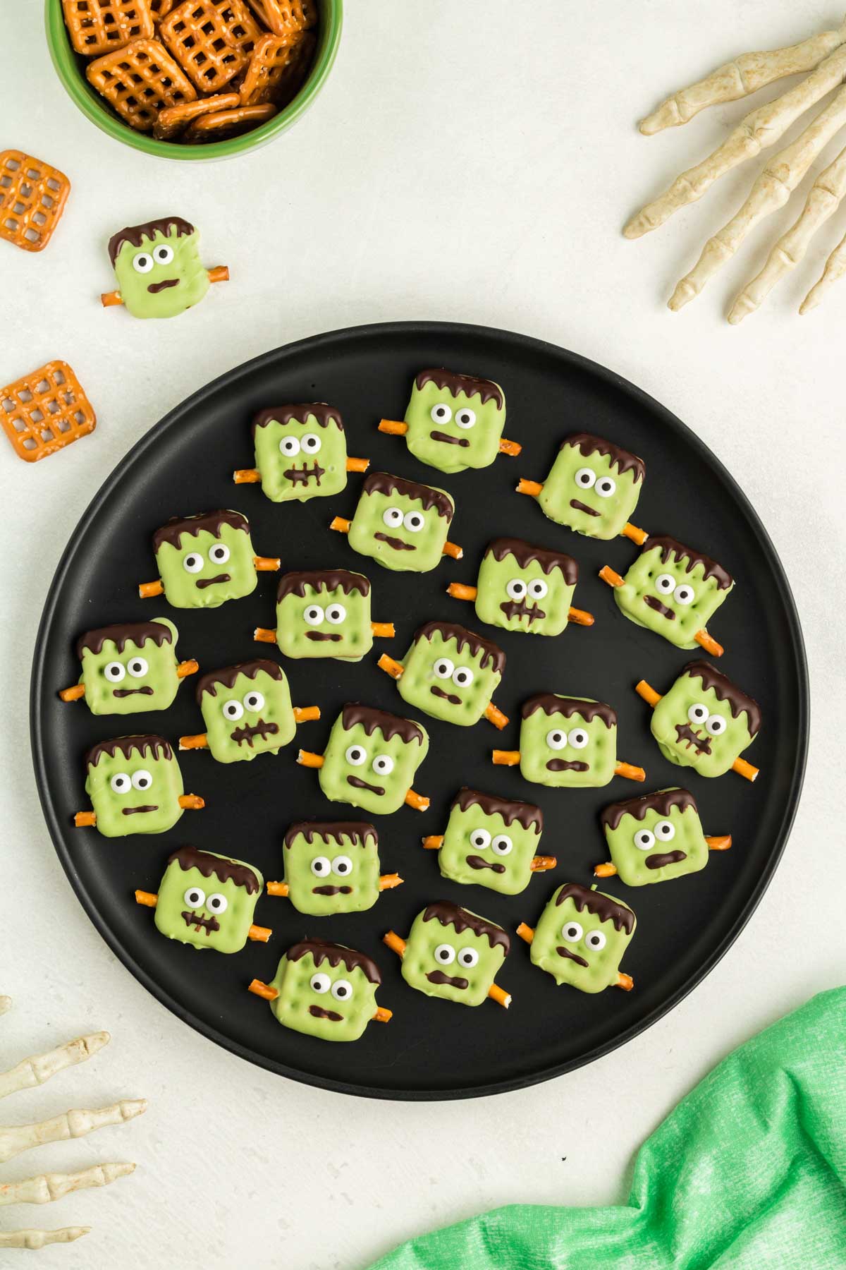 green plate with Frankenstein Halloween pretzels on them
