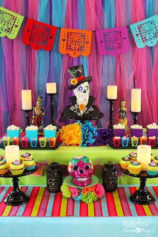 bright colored food table with day of the dead decorations