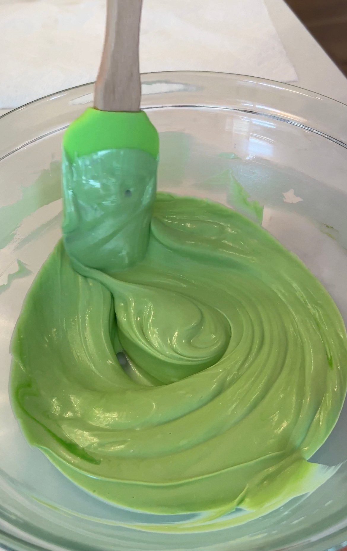 green candy melts melted in a glass bowl