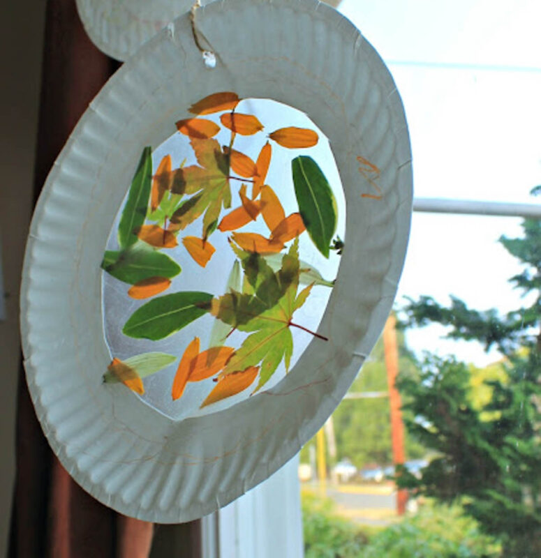 paper plate with leaves hanging in window