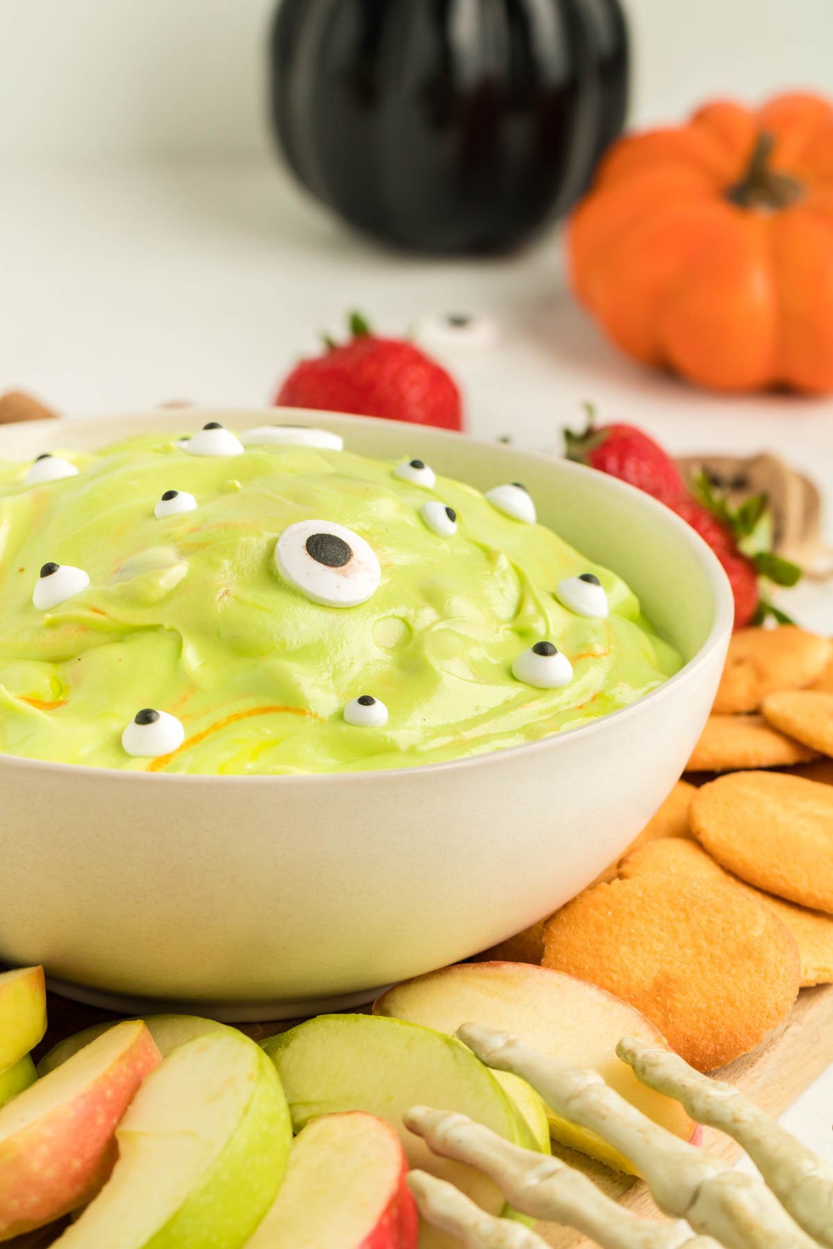 white bowl with a green marshmallow dip and dippers