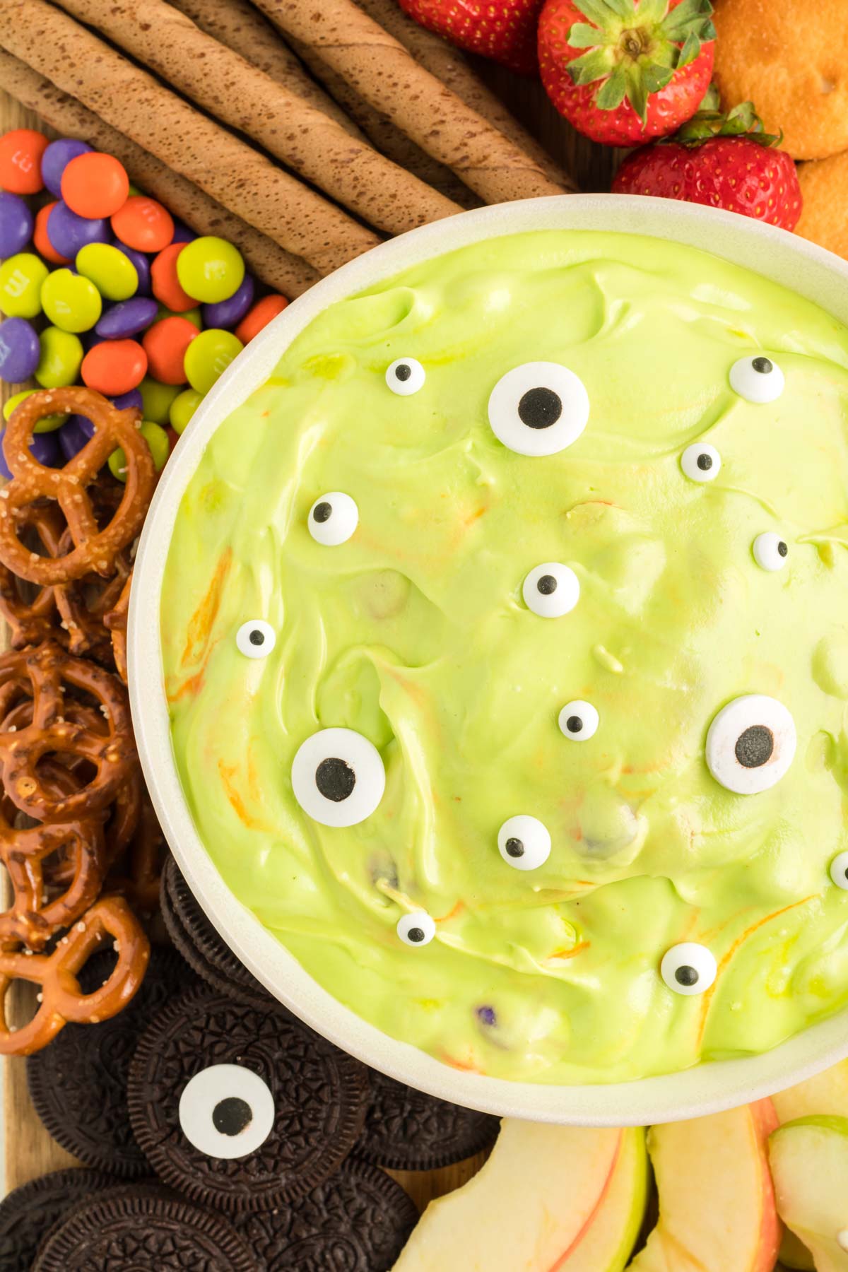 green monster dip in a white bowl with dippers