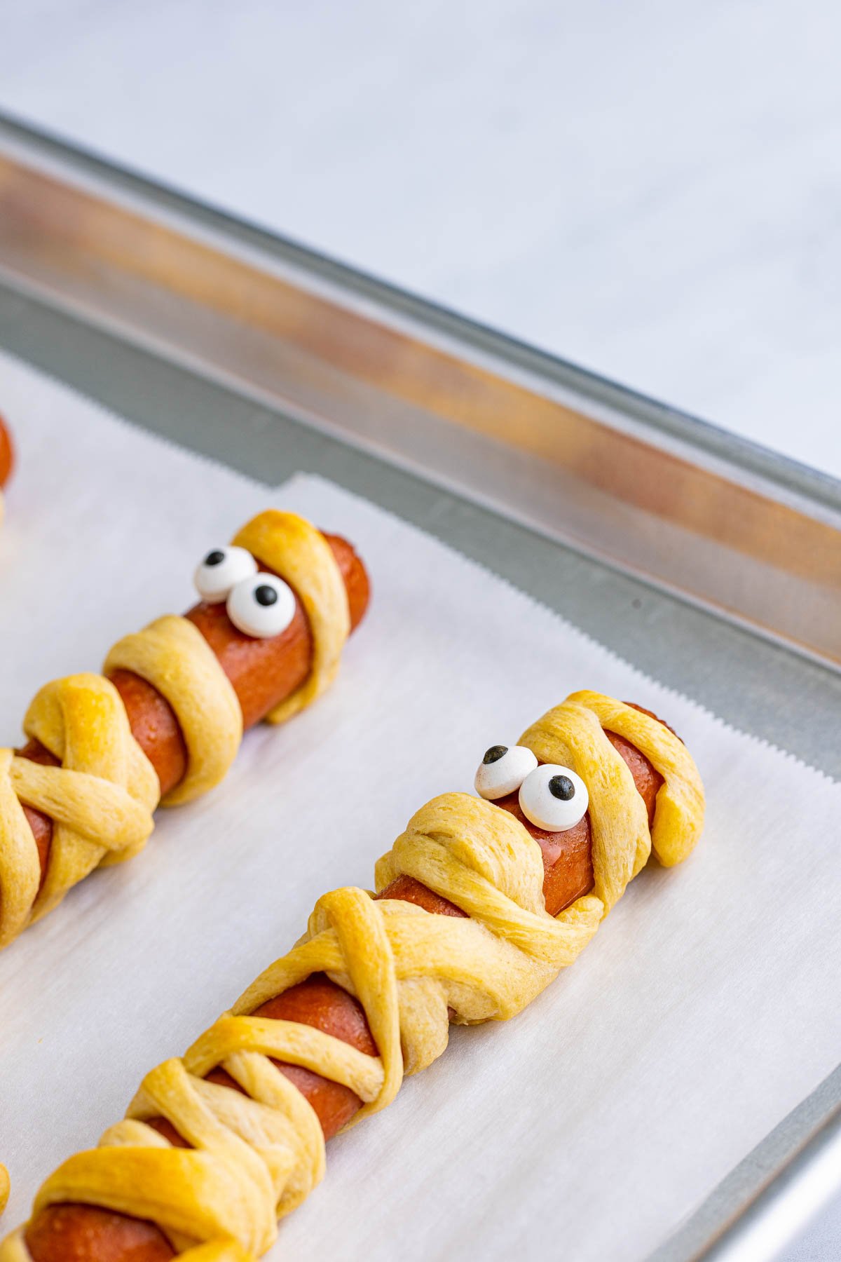 baking sheet with baked Halloween mummy dogs