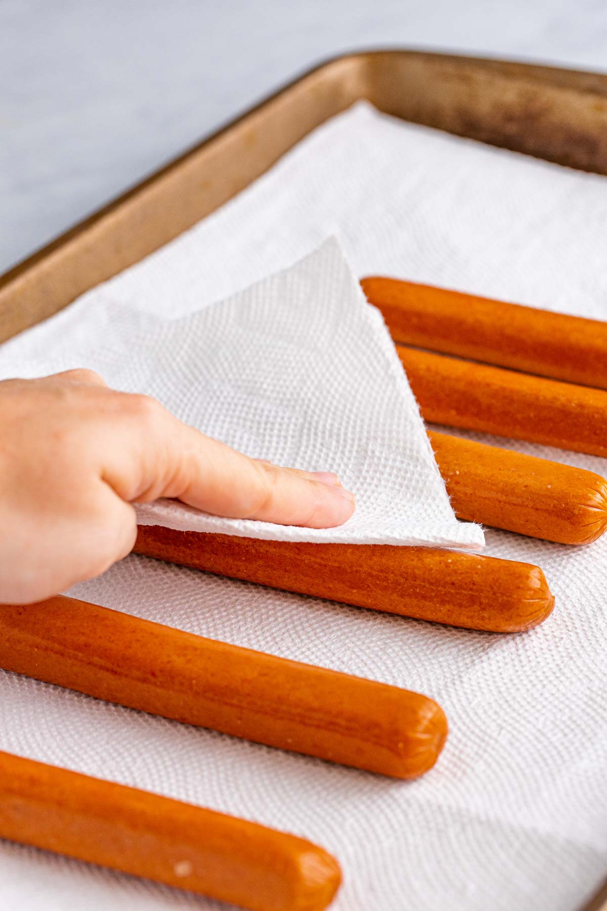 patting hot dogs with a paper towel