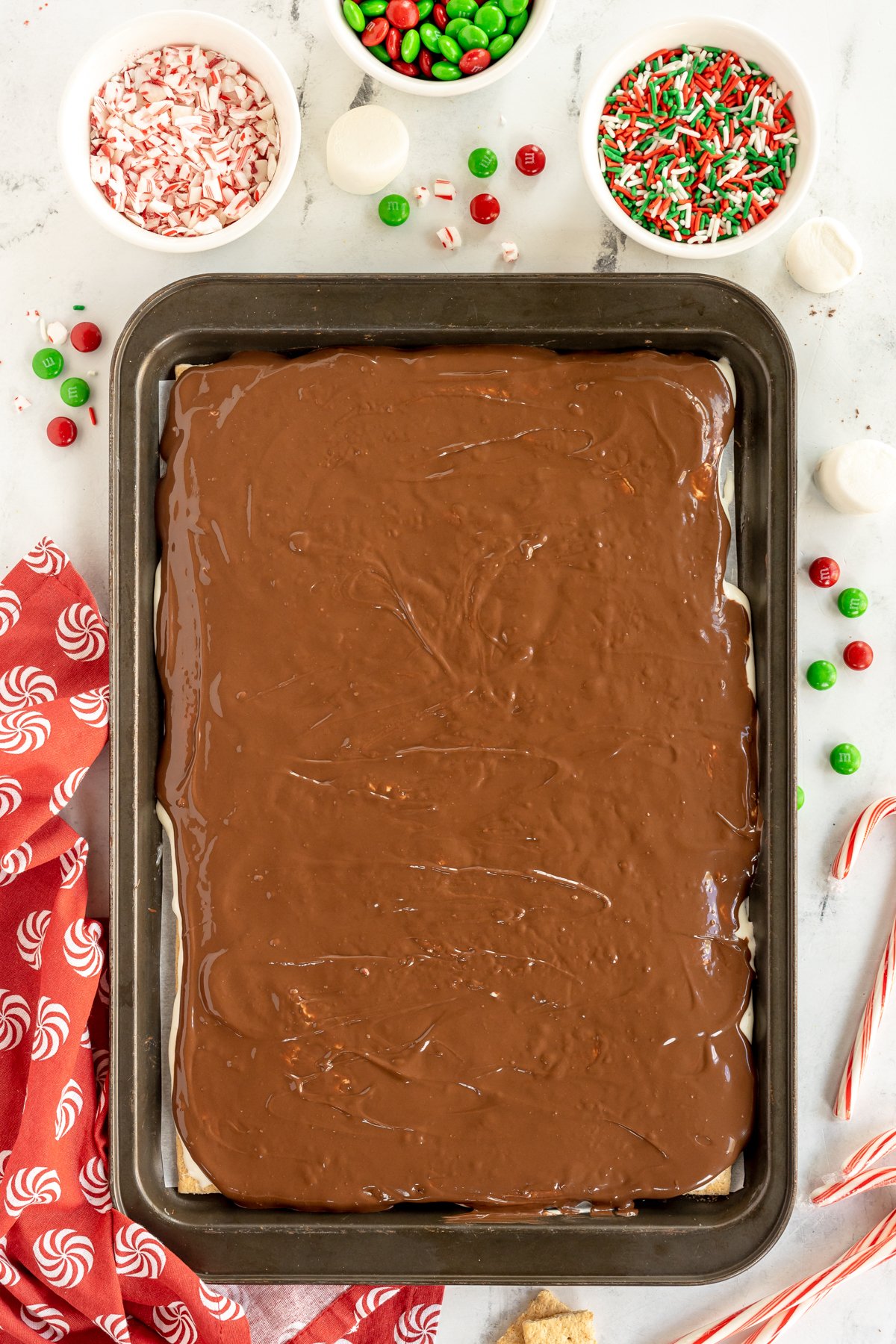 melted chocolate on a sheet pan of Christmas bark