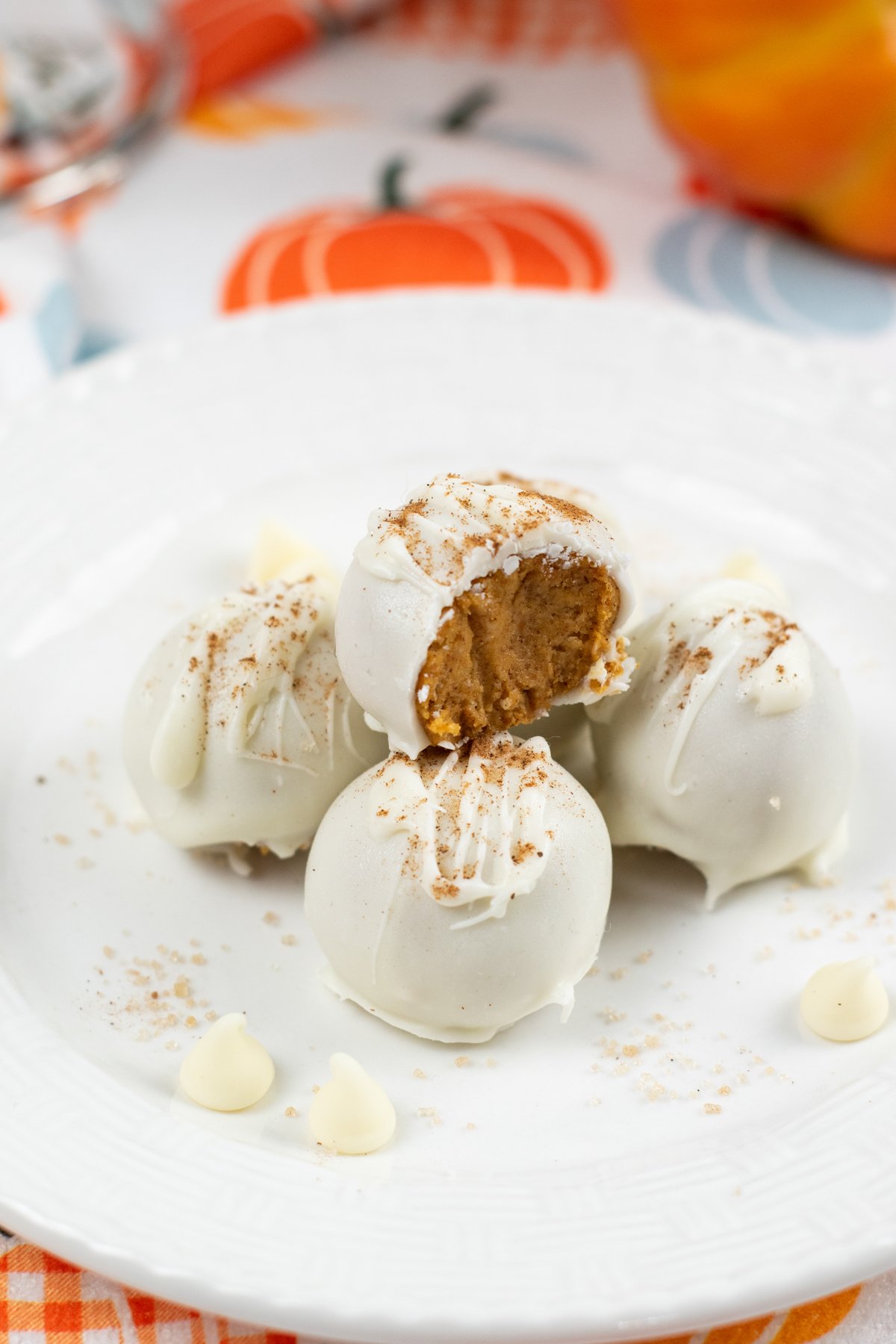 white chocolate pumpkin balls on a white plate