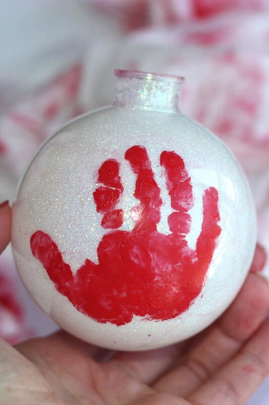 Red hand print on white ornament