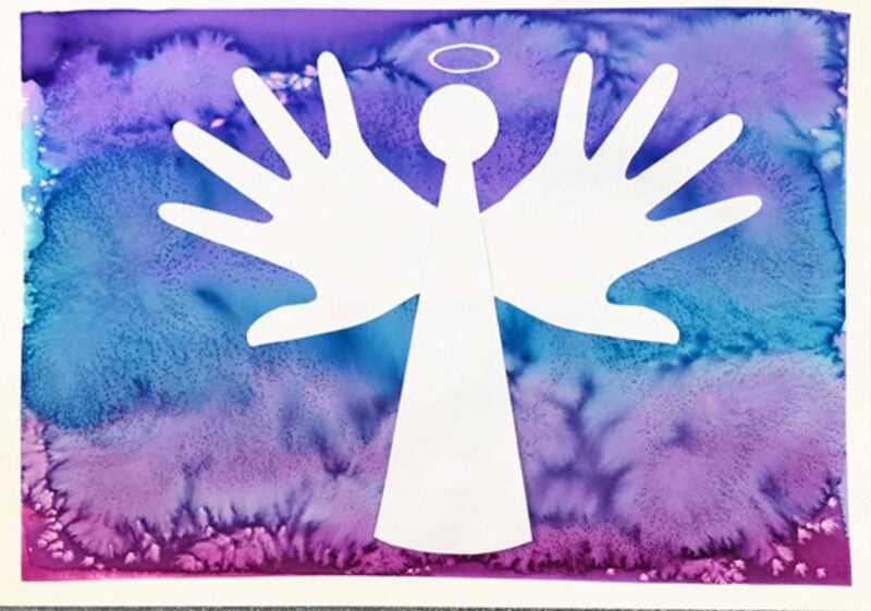 silhouette handprint angel on colorfully painted paper