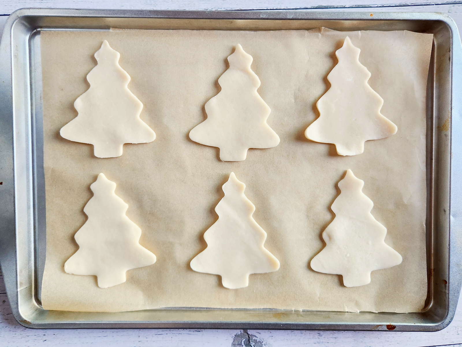 Christmas tree shaped pie crusts on a cookie sheet