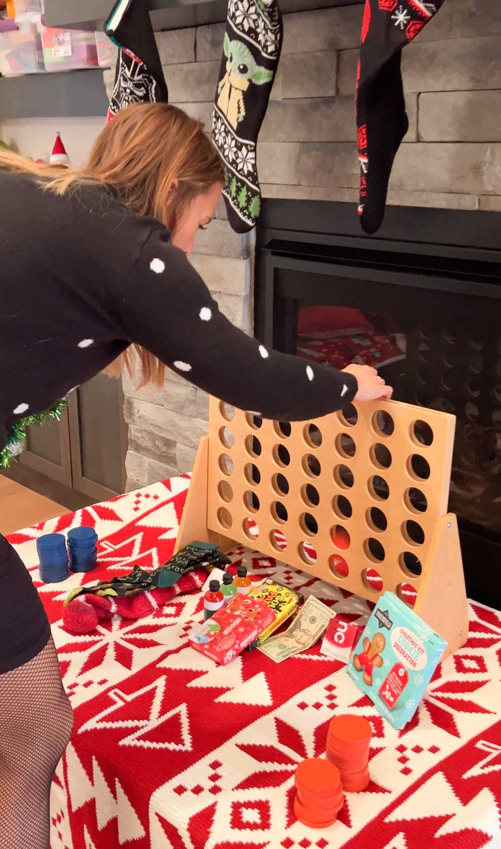 woman adding a coin to a connect four game