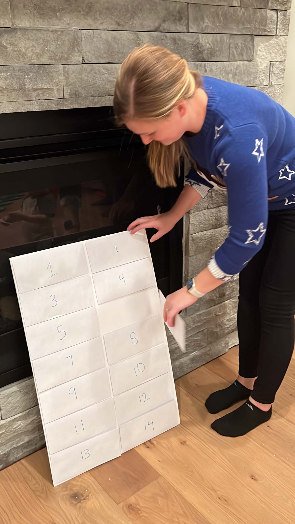 woman choosing an envelope from the back of a poster board