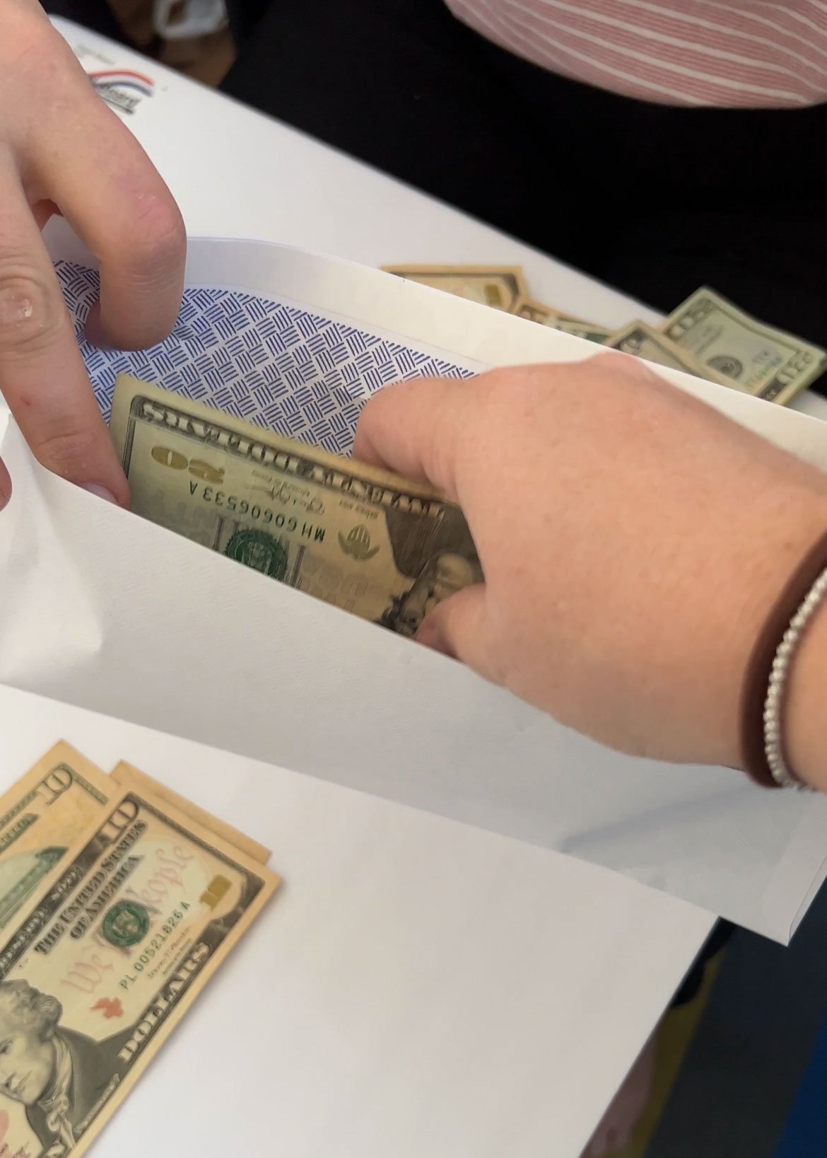 hand putting cash in envelopes for let's make a deal