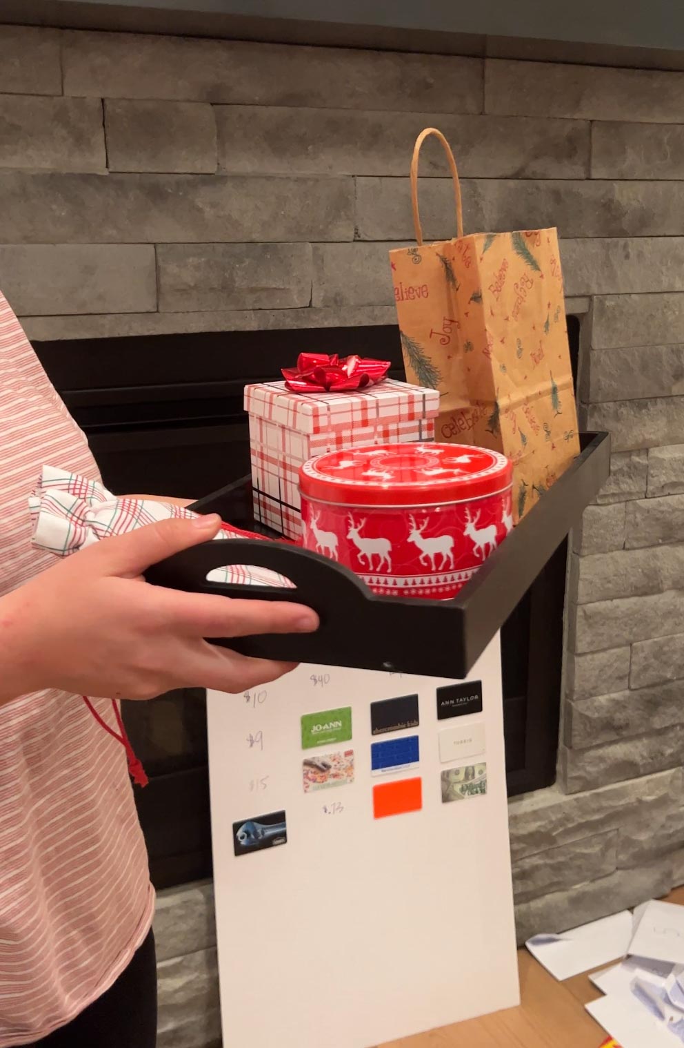 woman holding a tray of wrapped gifts