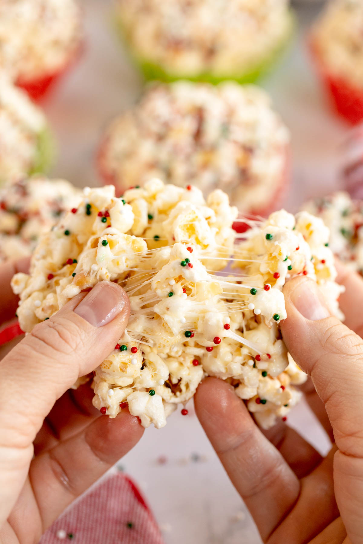 hand stretching a marshmallow popcorn ball