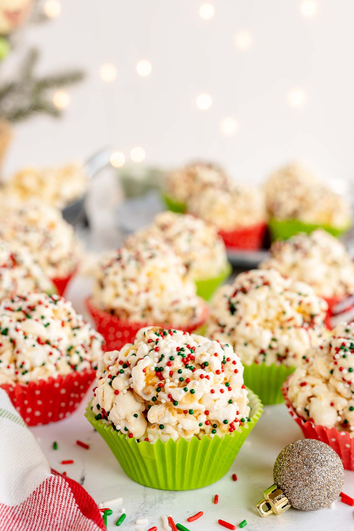 a plate full of Christmas marshmallow popcorn balls in cupcake liners