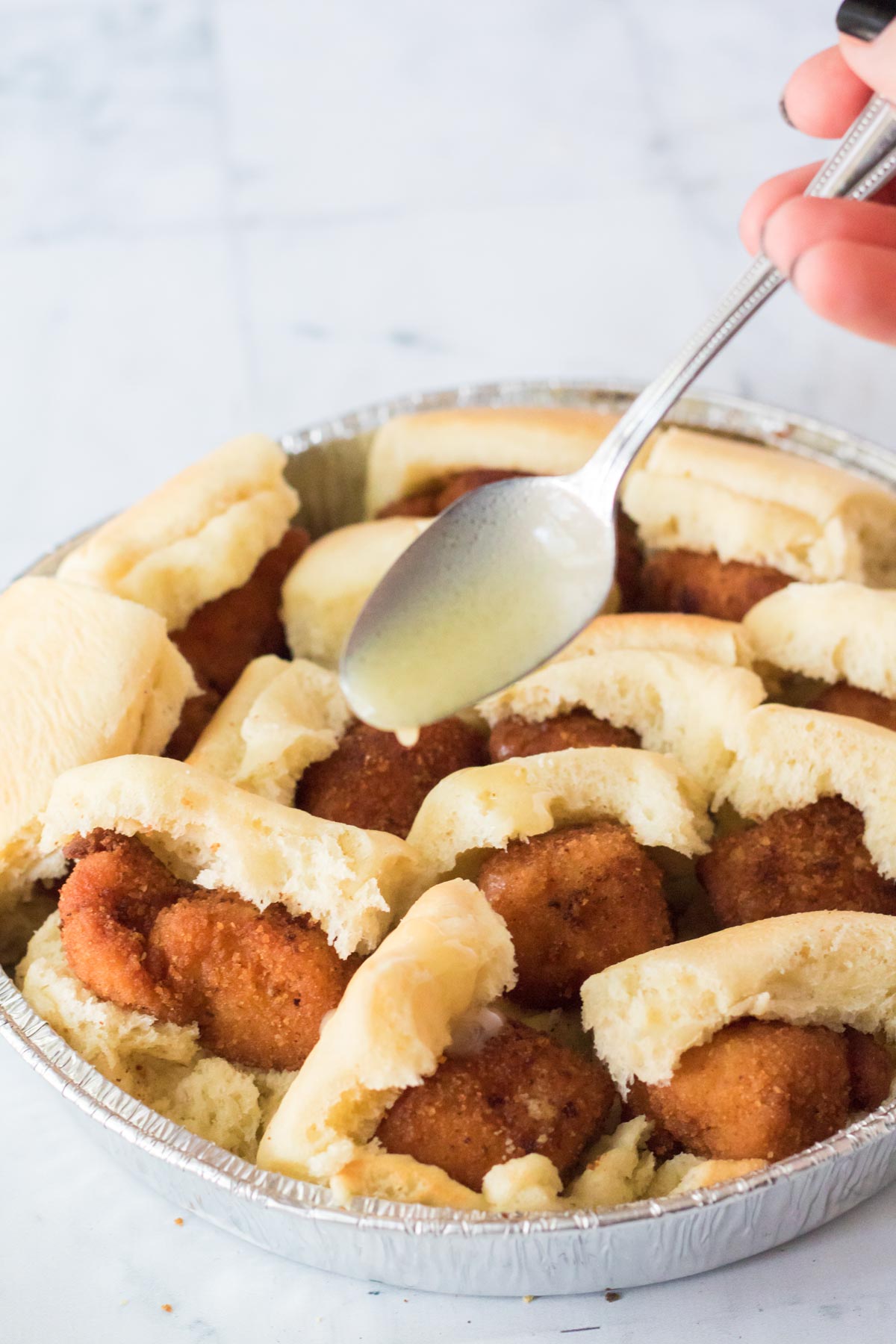 adding honey butter to rolls 