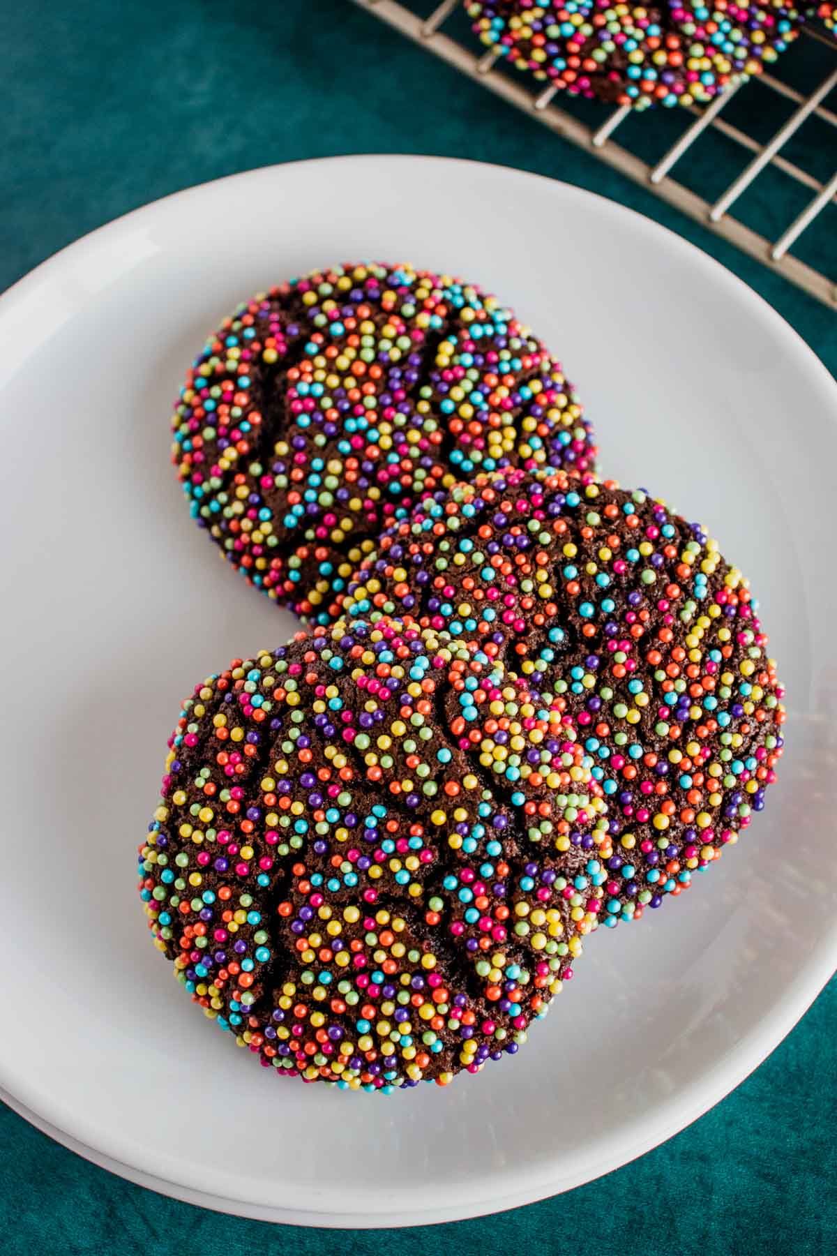 3 chocolate sprinkle cookies on a white plate