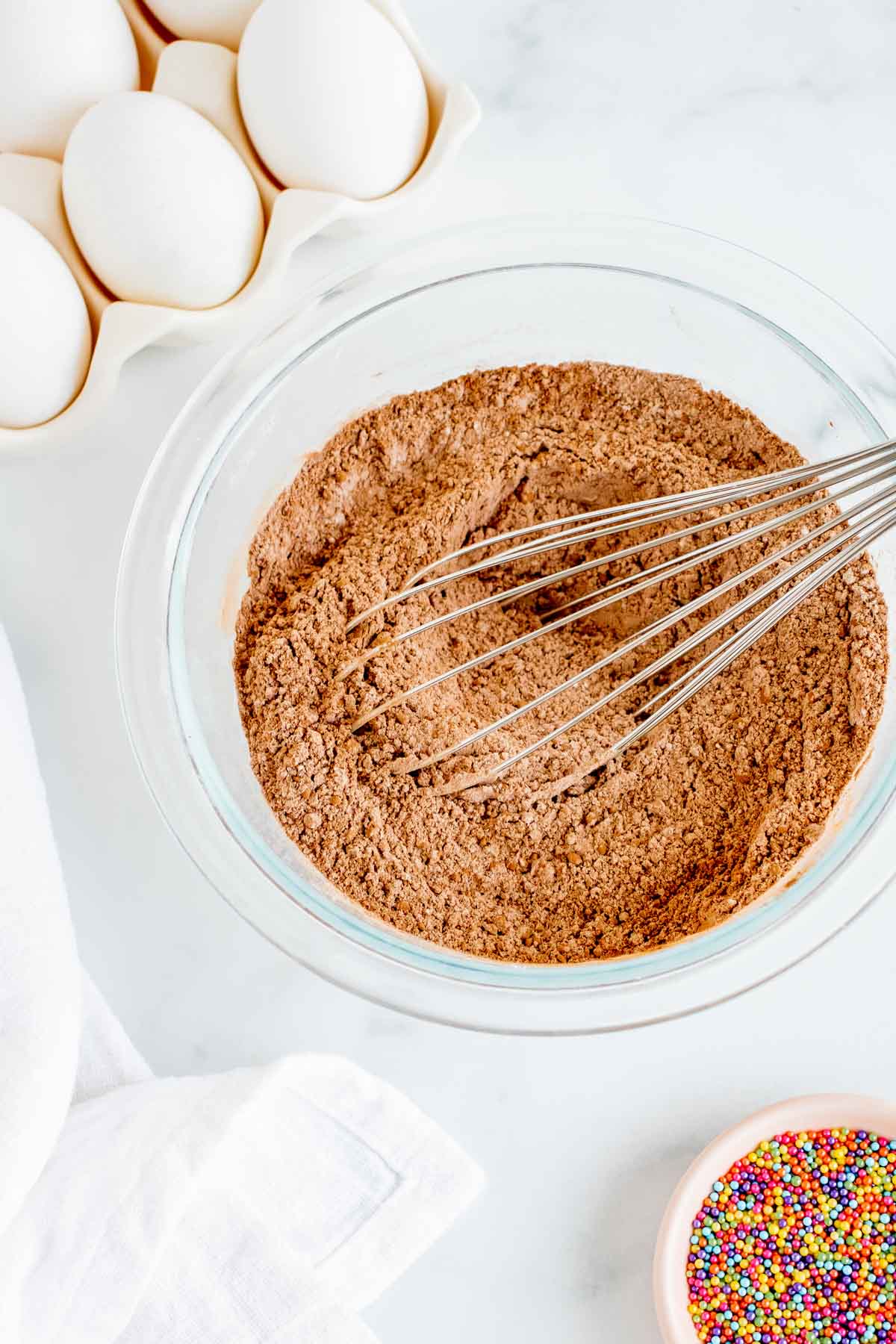 white bowl with dry ingredients and a whisk