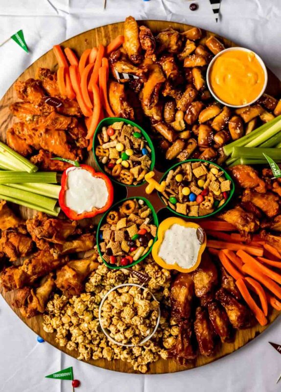large circular board with variety of snack mixes and wings